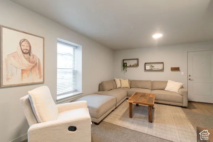 Recessed lighting, light-toned walls, a window with blinds, and wood-finish flooring
