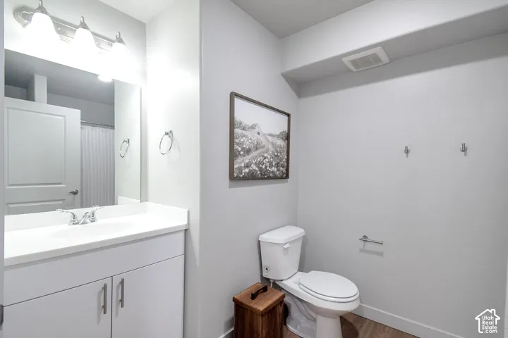 White vanity with chrome hardware, an integrated sink, and a framed mirror