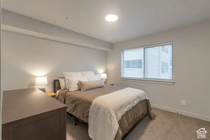 Recessed ceiling lighting, light gray wall paint, window with blinds, and neutral tone carpet flooring