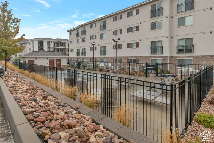 Fenced outdoor patio area with lounge seating, brick facade, and decorative window shutters