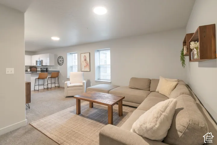 Open-concept living area with recessed lighting, light-colored walls, and two windows with blinds