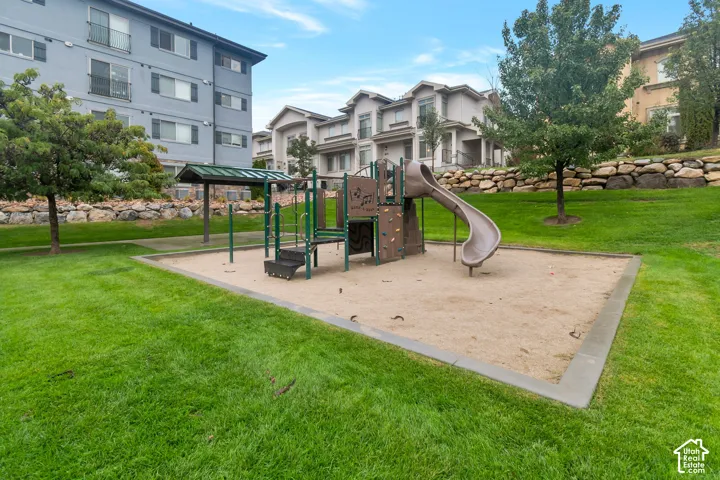 Playground area featuring a slide, climbing wall, and sand base