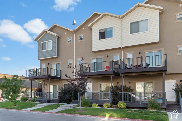 Multi-level townhome exterior featuring private balconies and ground-level patios
