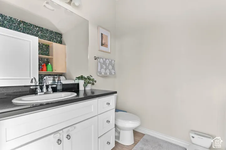 White vanity with a dark countertop and undermount sink