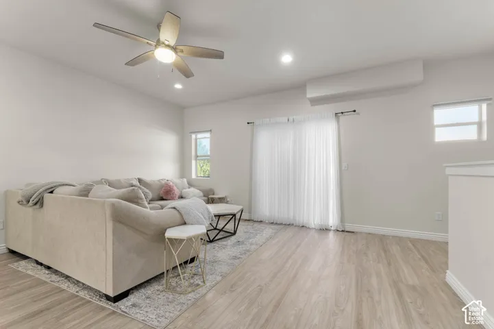 Wood-finish flooring, recessed lighting, ceiling fan, and sliding glass door