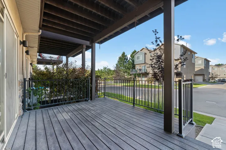 Spacious covered deck featuring composite decking and black metal railings