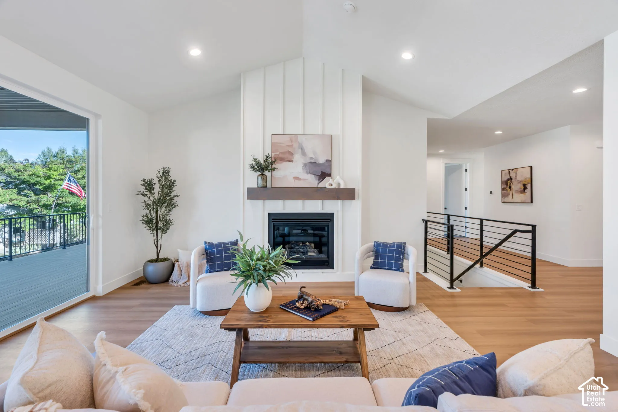 Bright open-concept living space anchored by a fireplace with white shiplap surround and wood mantel