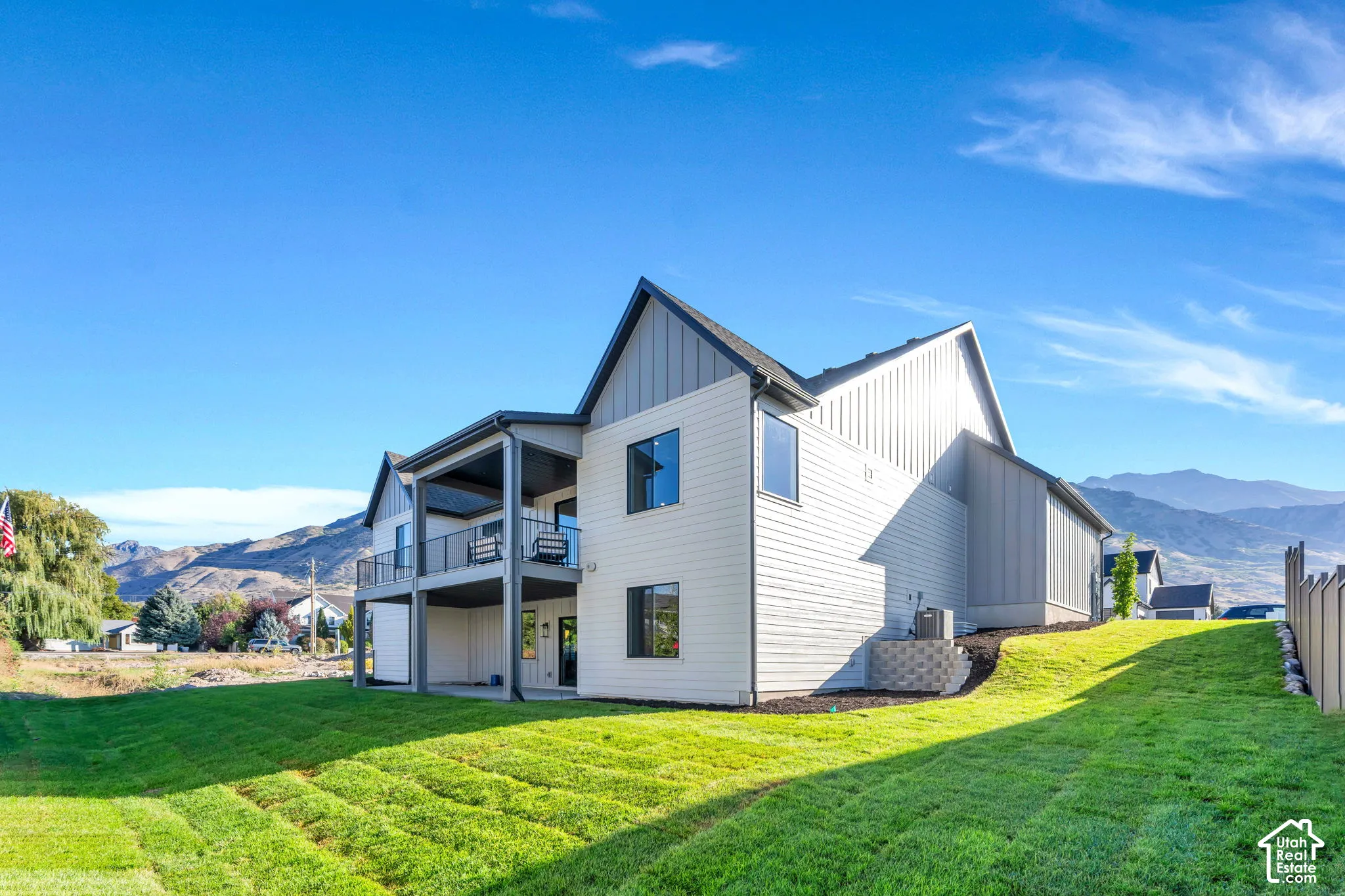 Modern exterior architecture featuring a prominent gable roofline and a covered upper-level balcony