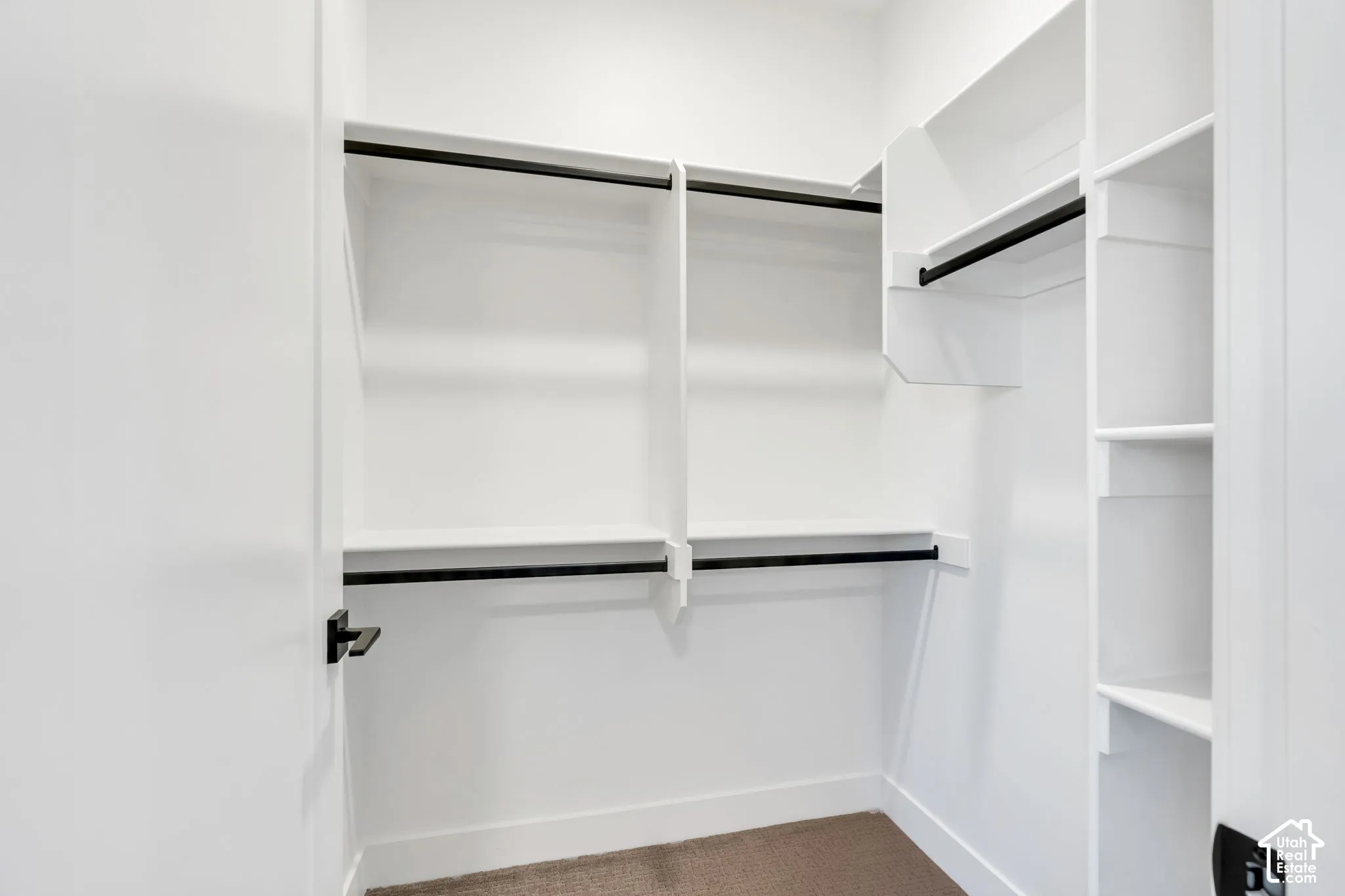White built-in shelving, multiple hanging rods, and an open layout