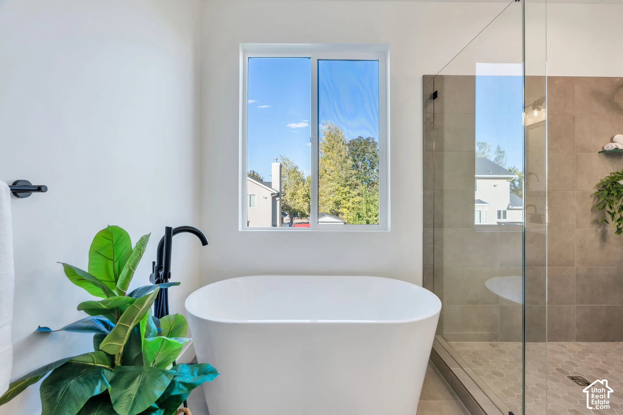Freestanding soaking tub with matte black floor-mounted faucet