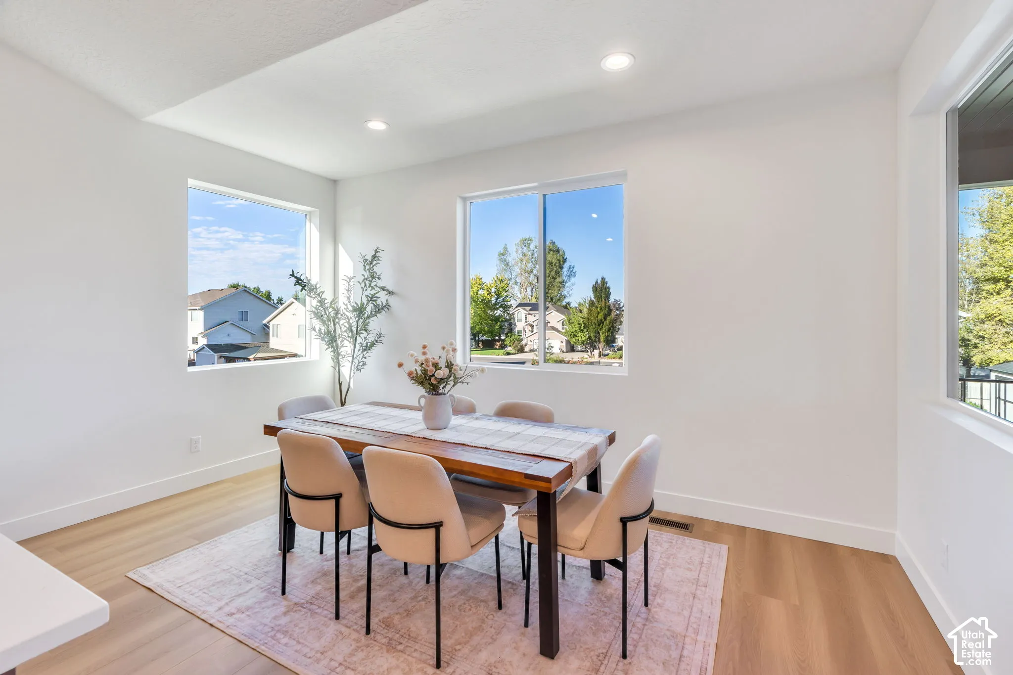 Recessed lighting, wood-finish flooring, white walls, and multiple windows