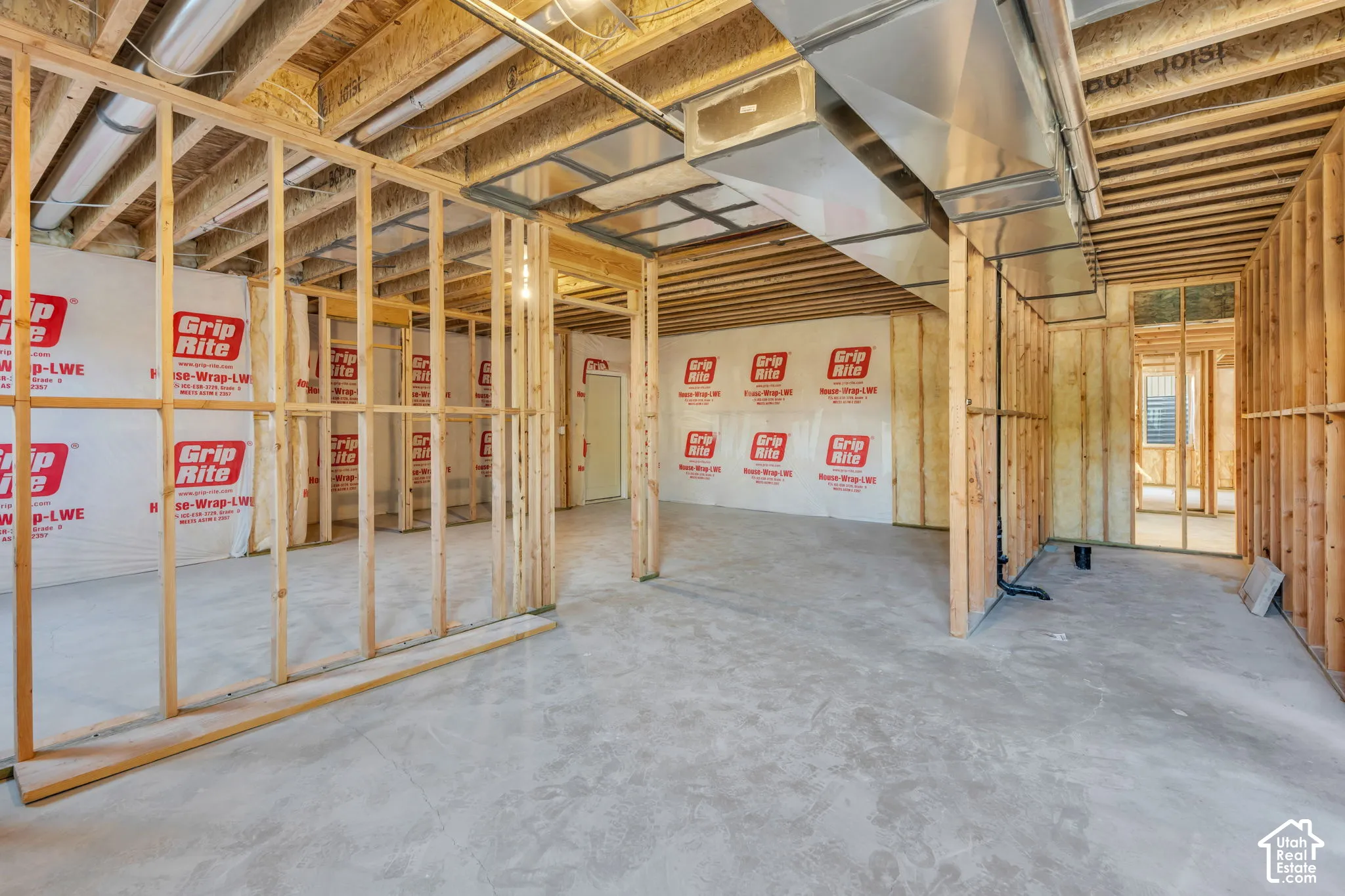 Unfinished basement space with exposed wood framing, concrete flooring, and visible ductwork