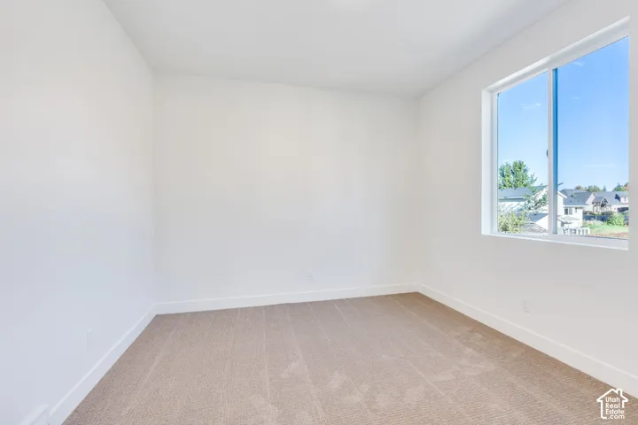 Neutral-toned carpeting with white wall paint and a large pane window
