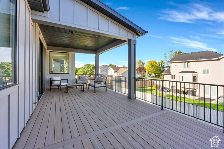 Covered outdoor deck with composite decking, recessed lighting, and black metal railing