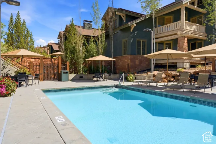 Outdoor swimming pool with tiled perimeter, surrounded by a stone paver deck