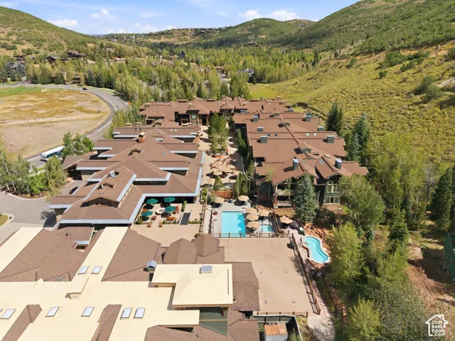 Multiple buildings with brown shingle roofs, integrated outdoor swimming pools, and a central courtyard