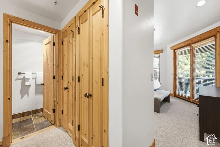 Wood-finish paneled doors with dark hardware, recessed ceiling lighting, and a private balcony with wood-frame glass doors