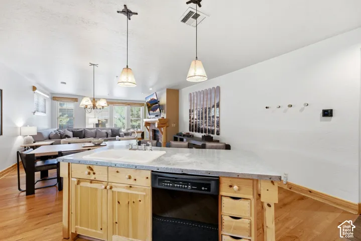 Kitchen island with integrated sink and dishwasher, wood-finish flooring, recessed lighting, and pendant light fixtures