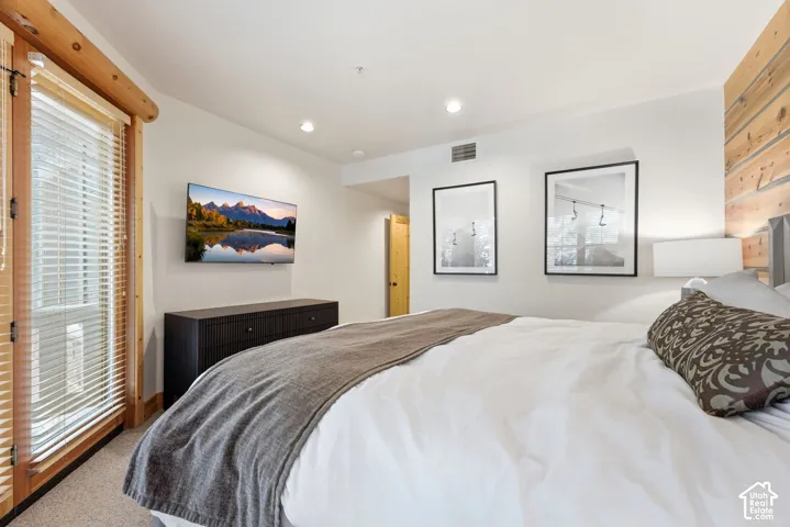 Wood-plank accent wall, recessed lighting, and wall-mounted television