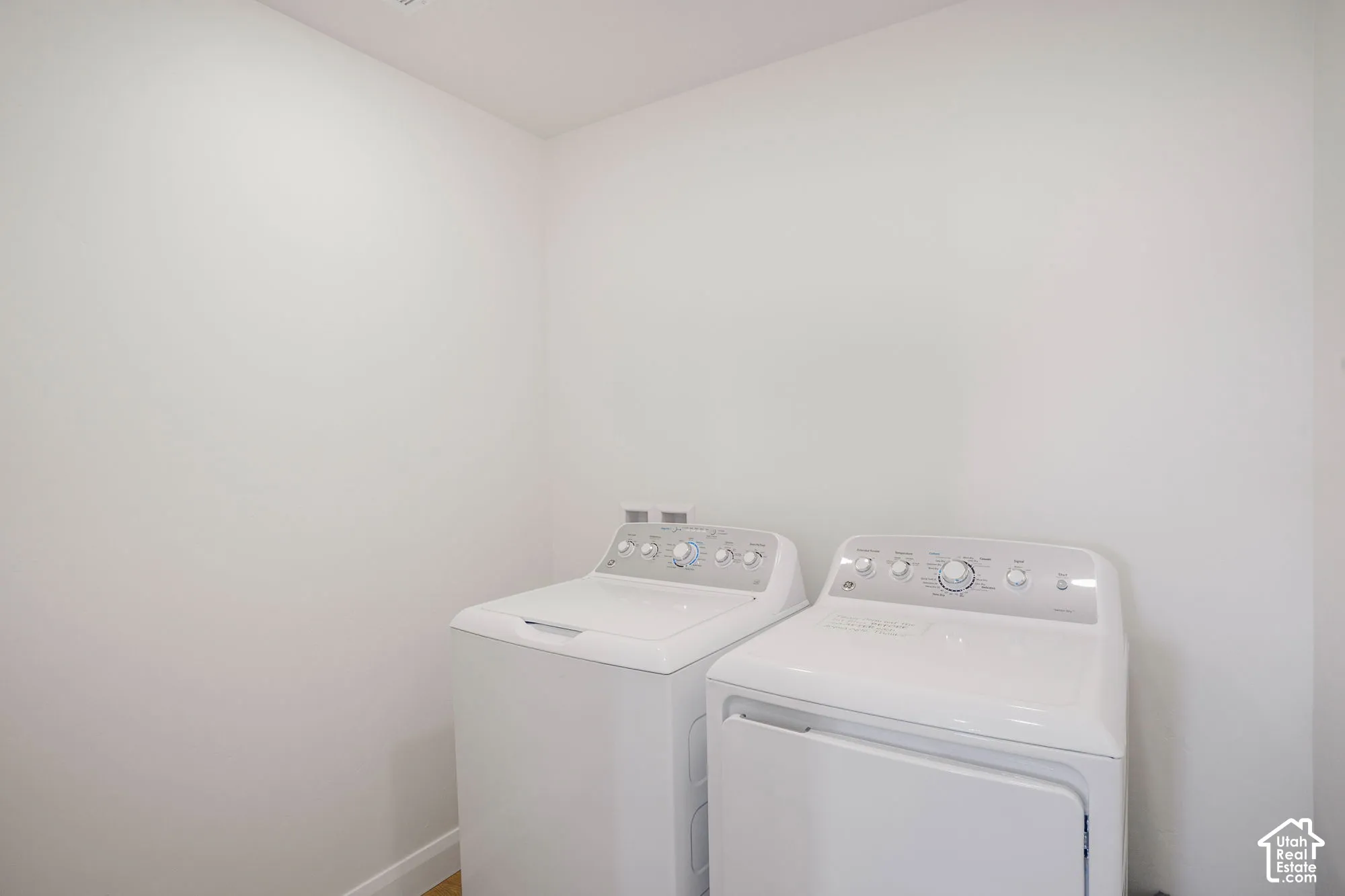 Laundry area featuring a top-load washing machine and front-load dryer