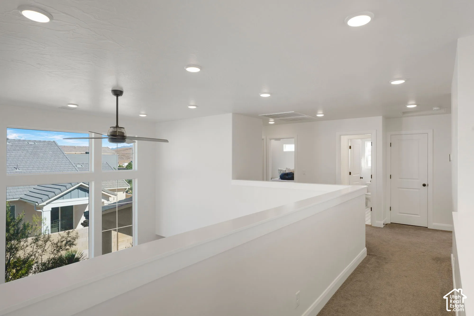 Loft area with a modern ceiling fan, recessed lighting, and large multi-pane windows