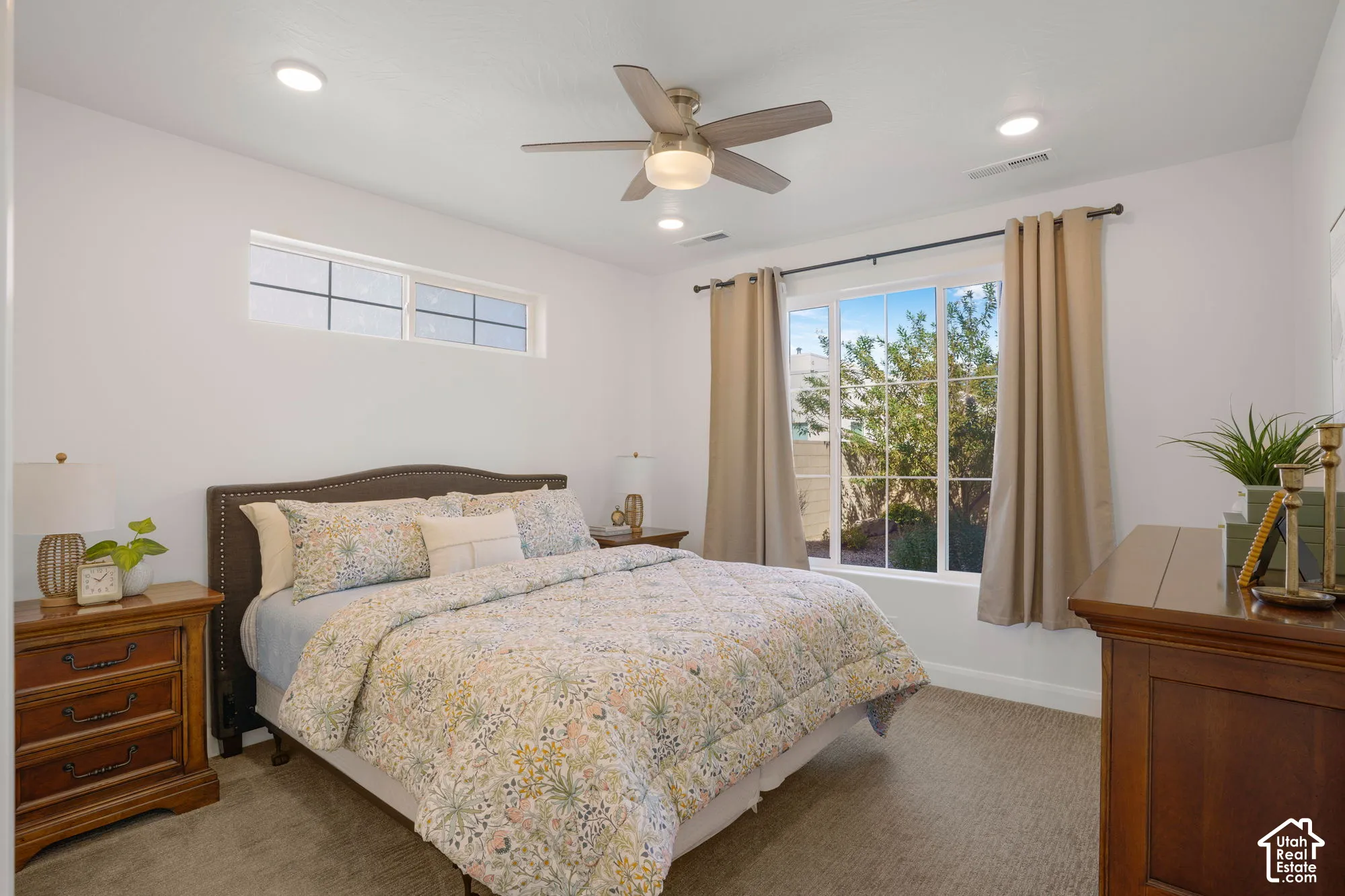 Recessed ceiling lighting, ceiling fan with integrated light, large window, transom window, and textured carpeting