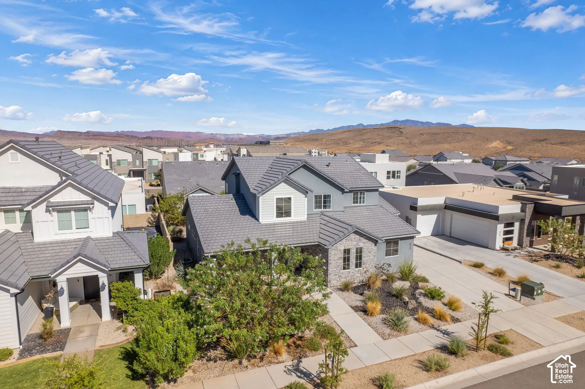 Contemporary residence featuring a light gray exterior, stone accents, and a dark gray tile roof