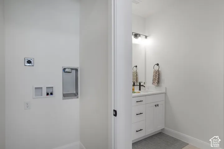 White shaker-style vanity with a white countertop and matte black hardware