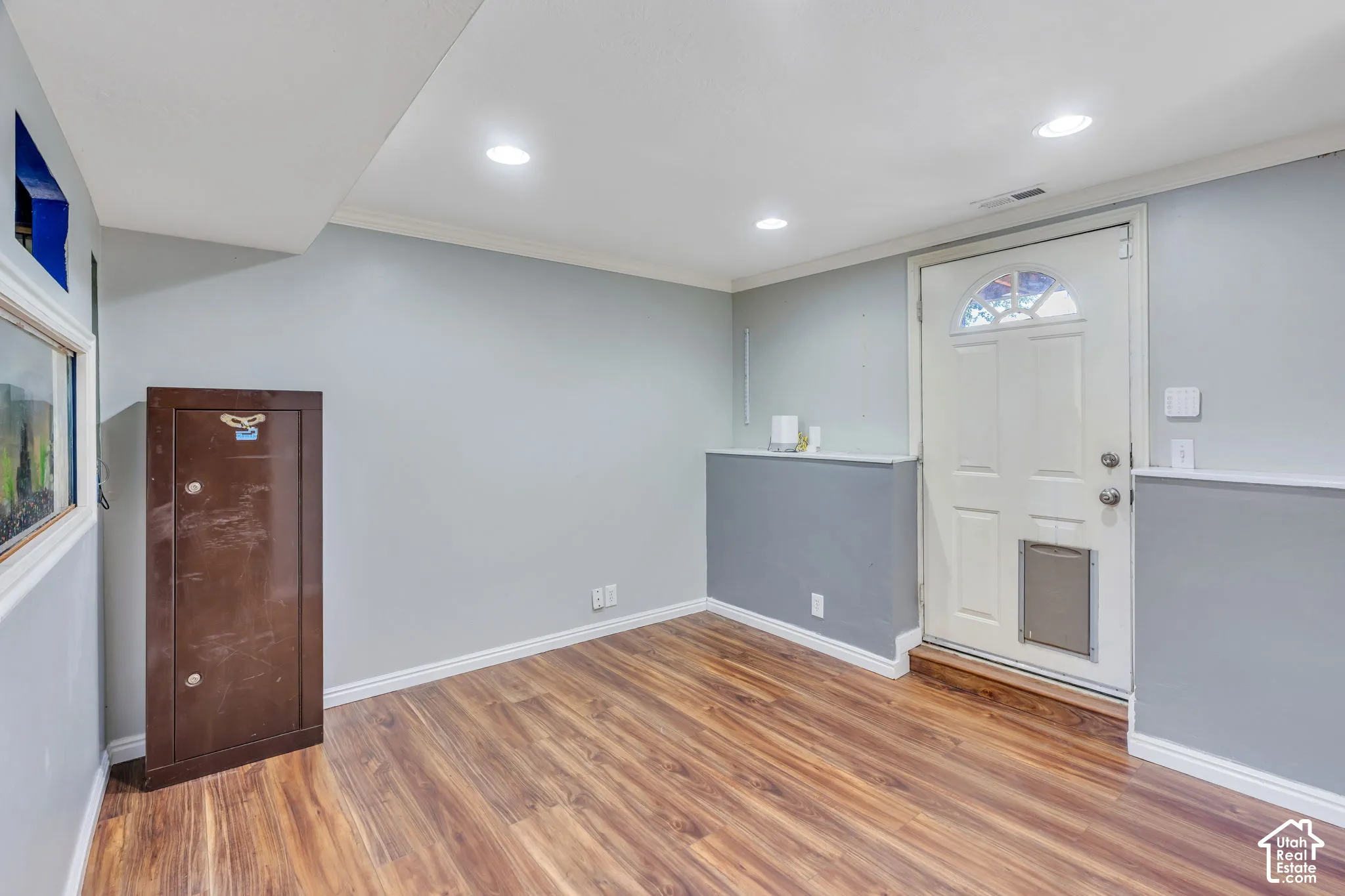 Wood-finish flooring with light gray walls, white trim, and recessed lighting
