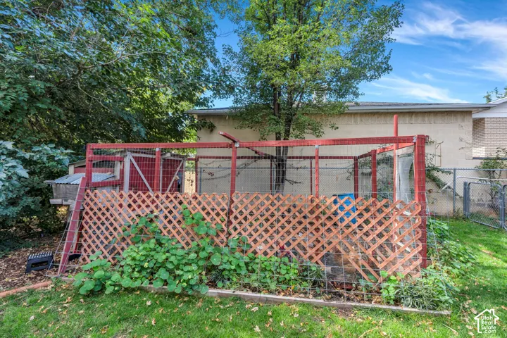 Fenced outdoor enclosure with a wooden lattice privacy screen and an integrated lean-to structure