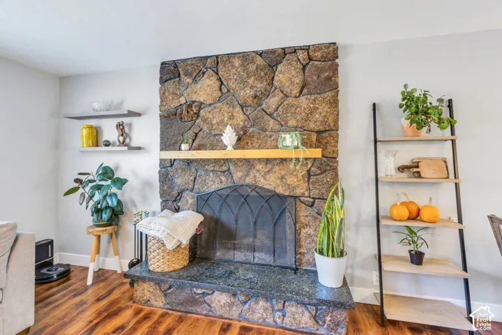 Stone-clad fireplace with a granite hearth and a wood-finish mantel