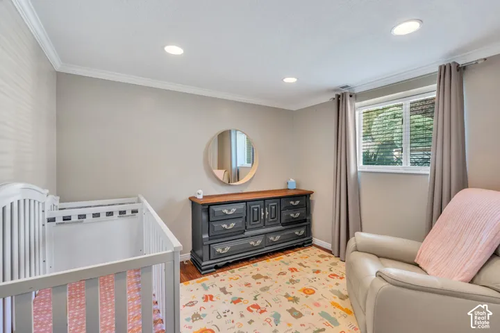 Recessed lighting, crown molding, wood-finish flooring, and window with blinds