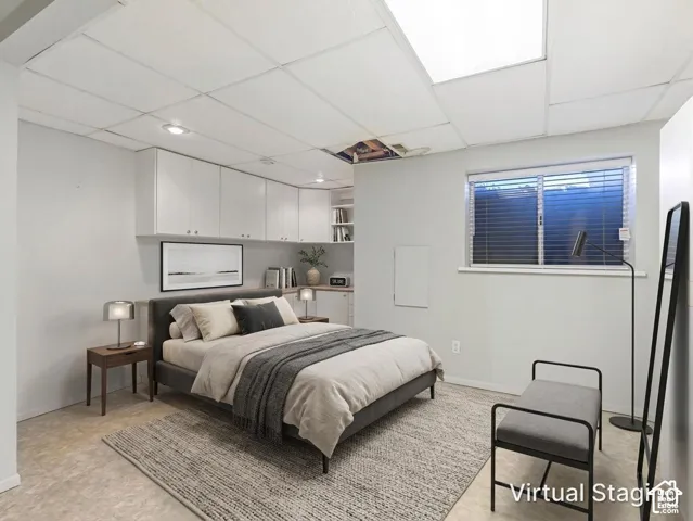 Room featuring white built-in wall cabinetry, recessed ceiling lighting, and a window with horizontal blinds