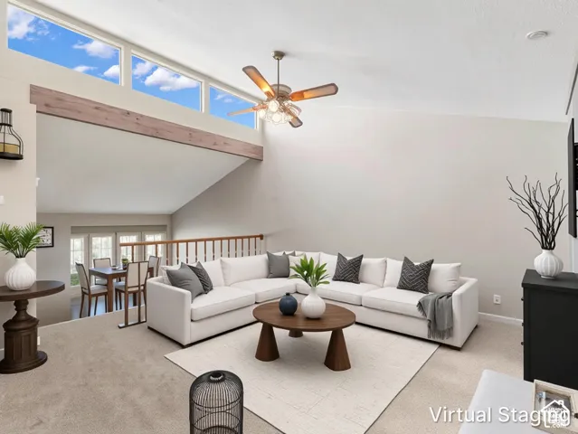 Vaulted ceilings, transom windows, wood-finish beam detail, and ceiling fan with integrated lighting