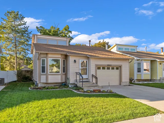 Light-colored siding exterior with a contrasting brown roof, a bay window feature, and an attached single-car garage