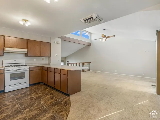 Kitchen with wood cabinetry, tile flooring, and white appliances