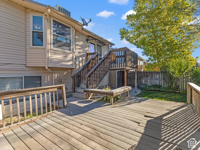 Multi-level wood deck with integrated bench seating, wood privacy fencing, and mature trees