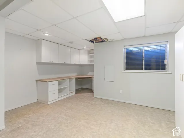 Built-in cabinetry with wood-finish countertops, overhead storage, and a drop ceiling with recessed lighting