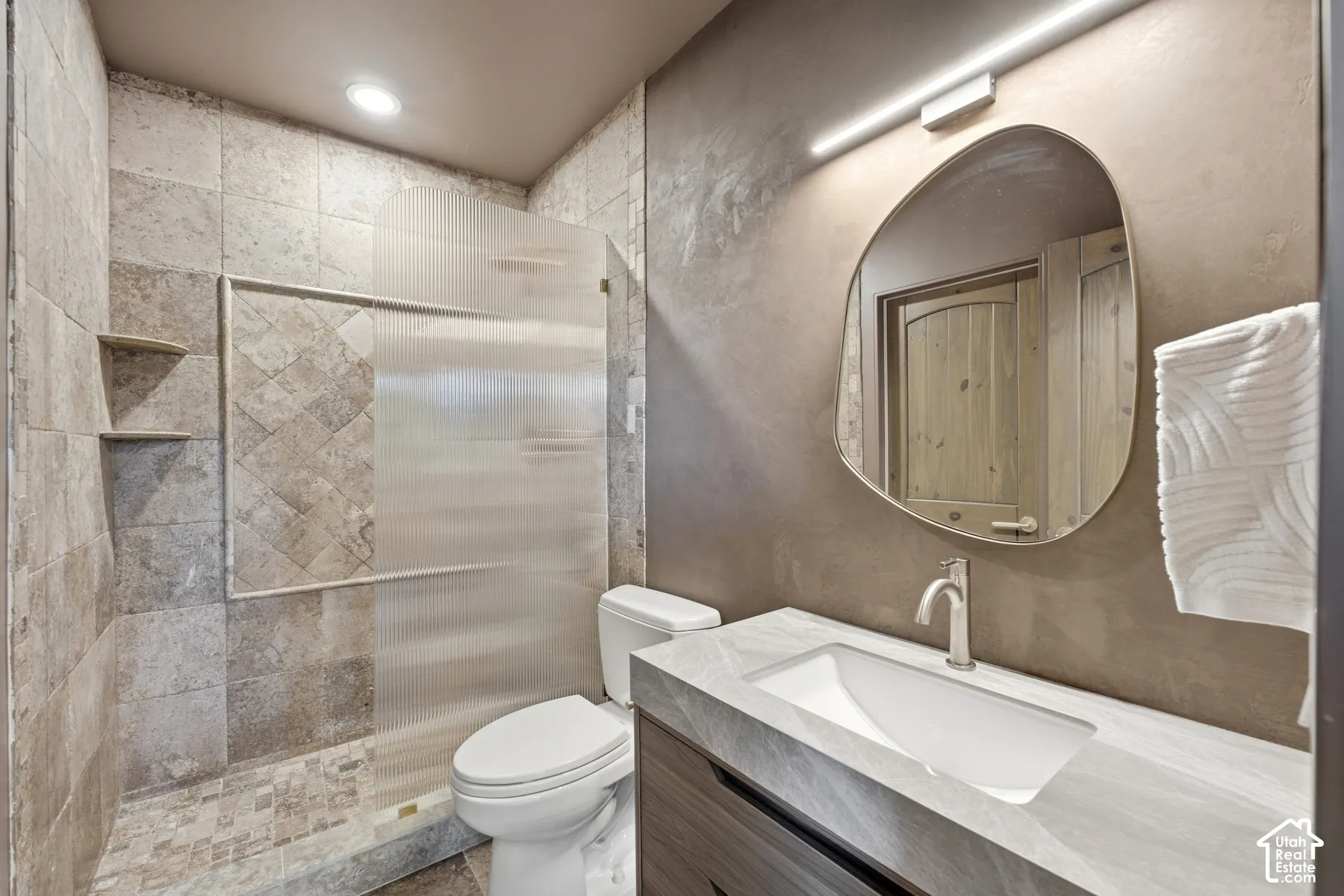 Walk-in shower with tiled walls and glass enclosure