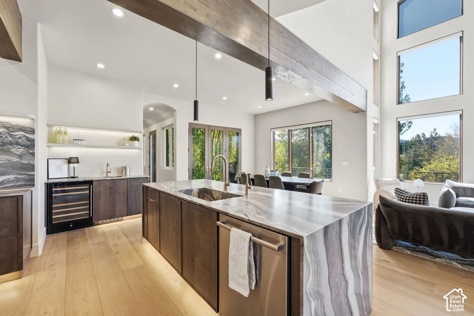 Expansive kitchen island with a waterfall countertop, integrated sink, and dishwasher