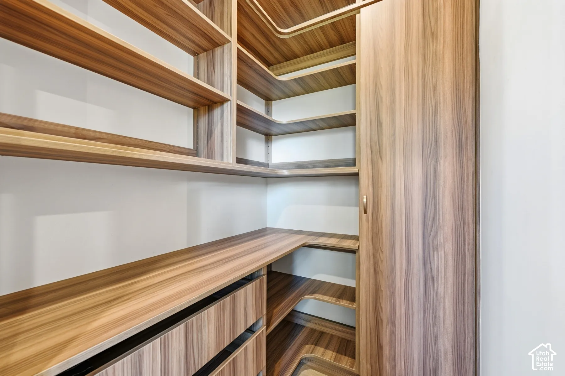 Built-in wood-finish shelving, integrated drawers, and a corner wardrobe cabinet provide extensive storage