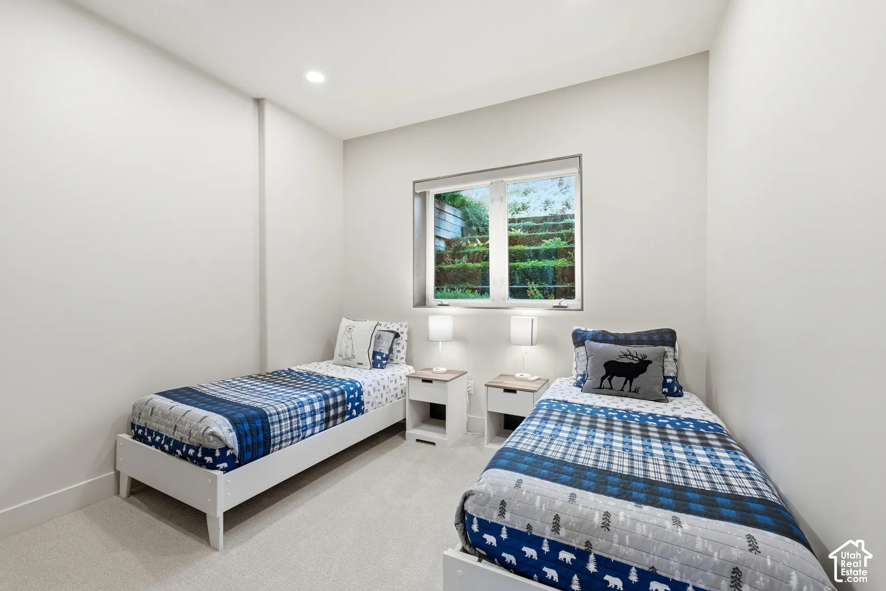 Recessed ceiling lighting, white walls, light-colored carpeting, and a window with white trim