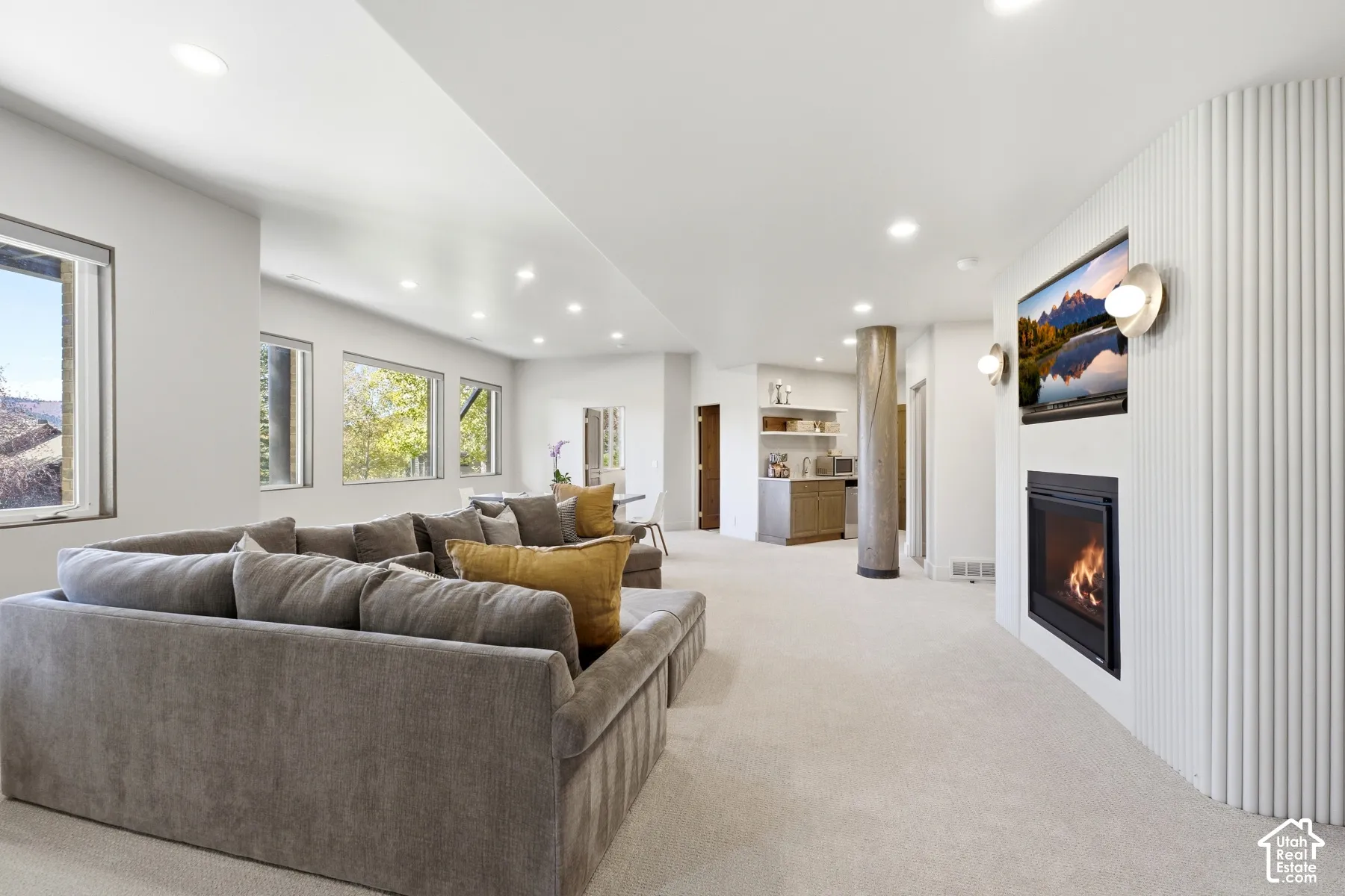 Recessed lighting, built-in fireplace, multiple windows, built-in wet bar, and light-toned carpeting