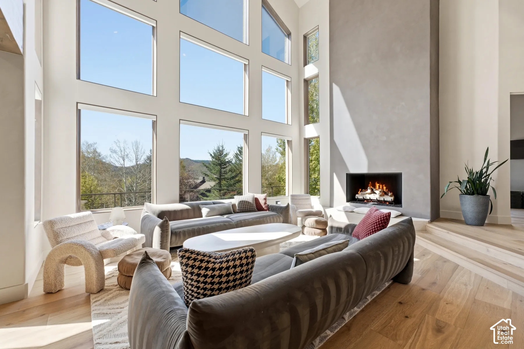 Two-story window wall, integrated fireplace, high ceilings, wood-finish flooring, and a multi-level floor plan