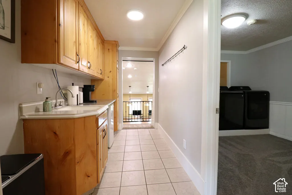 Built-in cabinetry with wood finishes, white countertop with an integrated sink, tile flooring, and overhead lighting