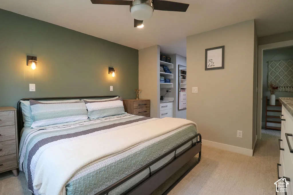 Recessed lighting, ceiling fan, built-in closet shelving, and wood-finish side tables