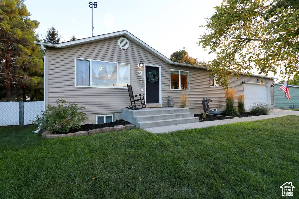 Welcoming front elevation featuring gray vinyl siding, a peaked roofline with circular gable window, and a concrete entry stoop with black entry door