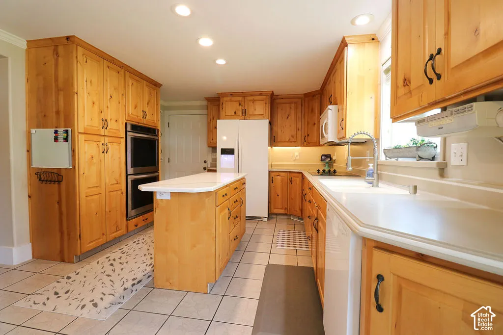 Kitchen featuring extensive wood cabinetry, white countertops, a center island, stainless steel double ovens, and tile flooring