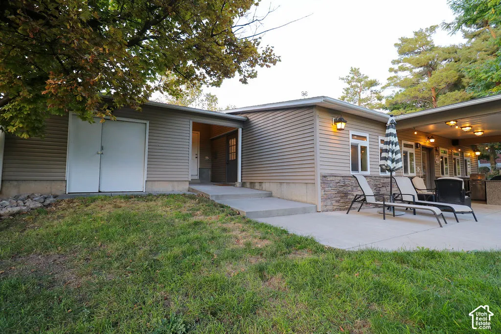 Exterior featuring stone veneer accents, horizontal siding, and a concrete patio