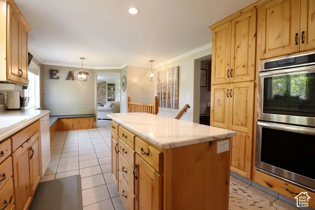 Kitchen featuring wood cabinetry, a center island with a light-toned countertop, integrated stainless steel double ovens, recessed lighting, and tile flooring